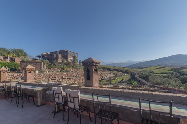 An outdoor terrace with stone tables and chairs, overlooking a mountainous landscape. - Dar Tafantant (Ourika)