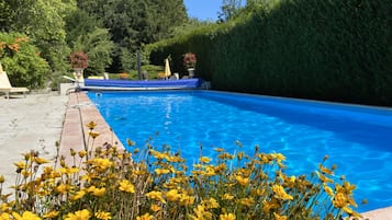 Una piscina al aire libre de temporada, sombrillas