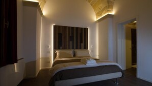 Un dormitorio moderno con una cama grande, un revestimiento de pared de madera y un techo curvo.