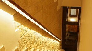 Una escalera con un revestimiento mural de textura única y una barandilla de madera.