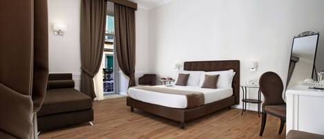 Habitación de hotel con una cama grande, un escritorio, una silla y vistas al exterior.