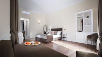A modern hotel room with a bed, a dining table with breakfast, a wardrobe, and a mirror.