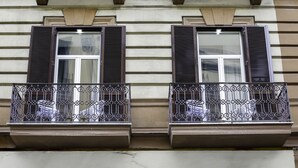 A building facade with two windows, each with shutters and a balcony with ornate metal railings. - La Fontanina Suites (Naples)