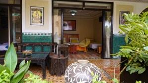 A room with a checkered floor, a sofa, a chair, a table, and a decorative vase. - Riad Saida Atlas (Lalla Takarkoust)