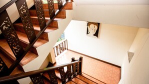 Una escalera con barandillas metálicas decoradas y suelo de baldosas.