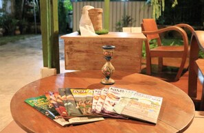 A round wooden table with a globe and several travel magazines. - Good Mood House (Chiang Mai)