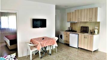 Un espacio habitable compacto con comedor, lavadora y kitchenette.