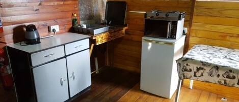 A compact kitchen with a refrigerator, a microwave, and a coffee maker.
