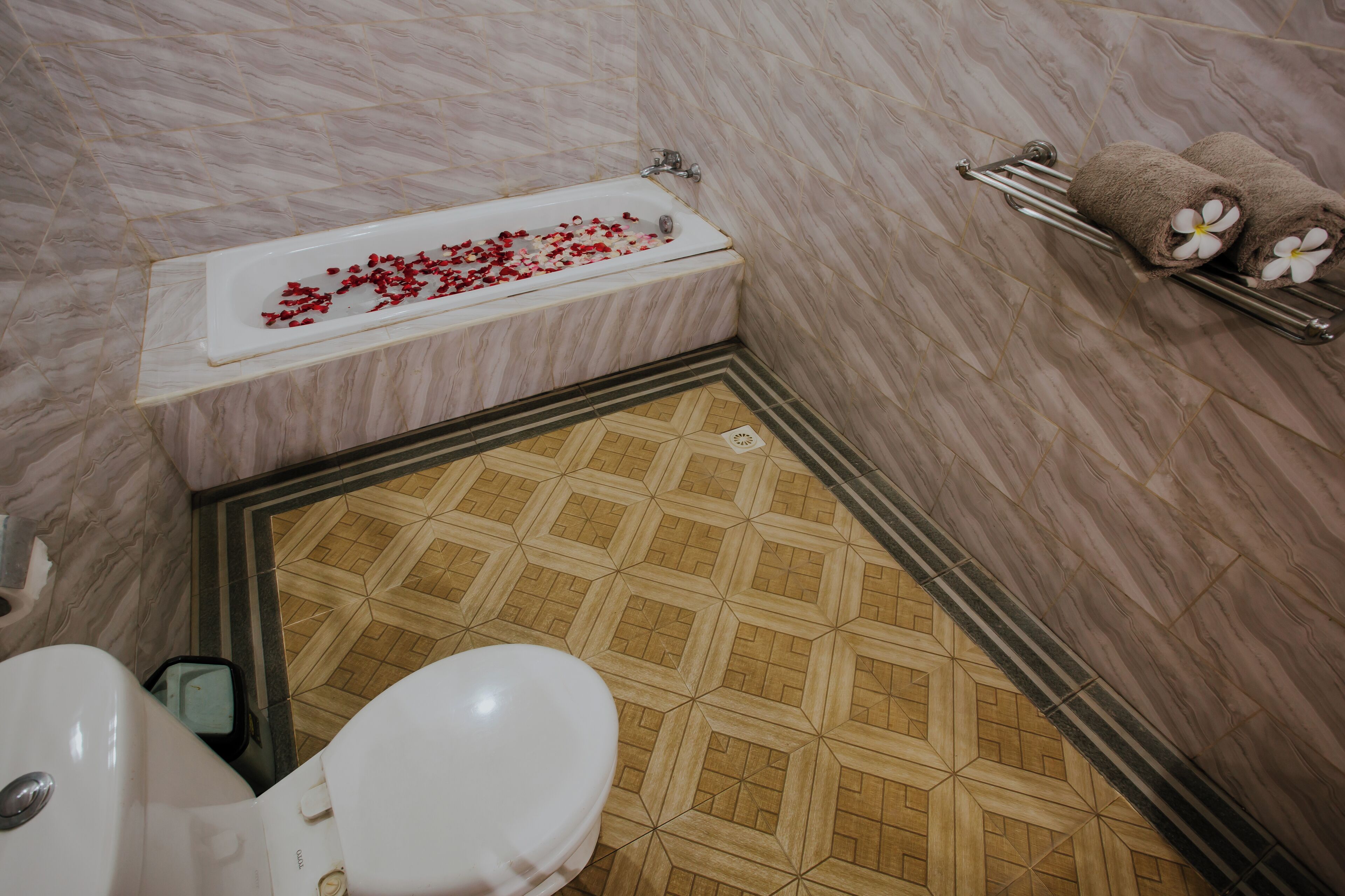 A bathroom with a bathtub, toilet, and shower area.