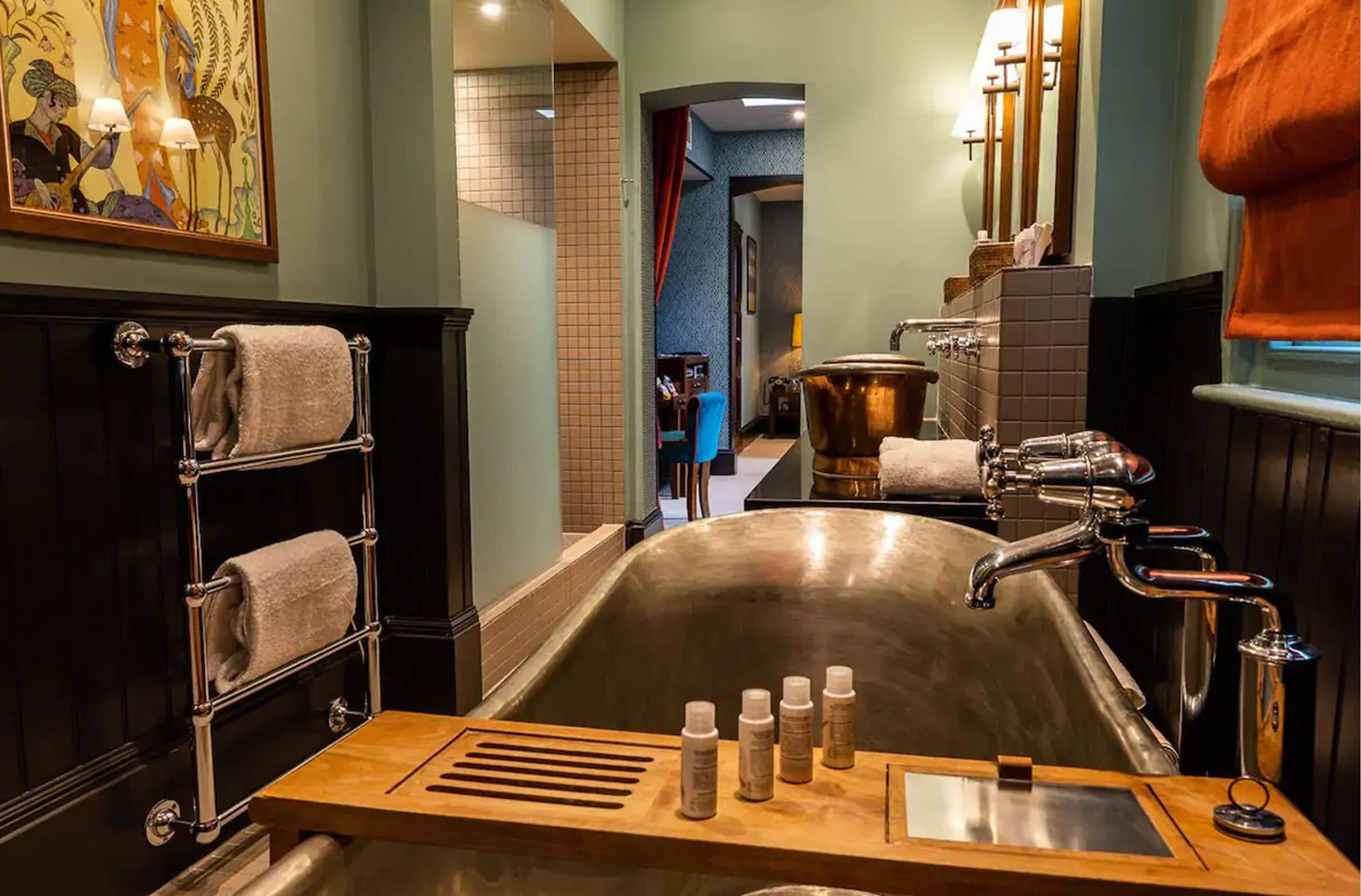A bathroom with a large bathtub, a towel rack, and a sink with modern fixtures.