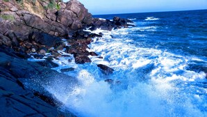 A rocky coastline with waves crashing against the rocks. - Paradise Beach House (Talalla)