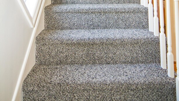 A carpeted staircase with white railings and a framed picture on the wall. - City's Escape (Pemberton)