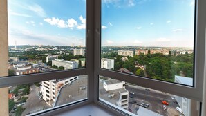 A cityscape through a window with a clear sky. - Homestay Apartments (Chisinau)