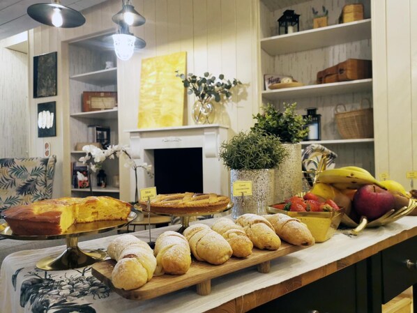 A bakery display with various baked goods and fresh fruits. - Epoca Home (Cosenza)