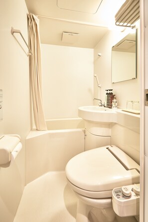 A compact bathroom with a toilet, sink, and shower area. - WAGOKORO - Hostel (Tokyo)