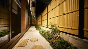 Un sendero estrecho con piedras para pisar que conduce a la entrada de un edificio.