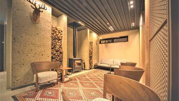 A cozy room with a fireplace, a patterned rug, and wooden furniture.
