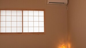 Quarto com cama, janela com vista, ar condicionado e luminária suspensa.
