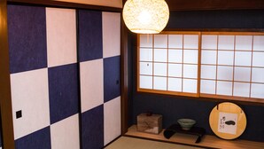 Um quarto japonês tradicional com tatames, painéis shoji e um lampião de papel suspenso.