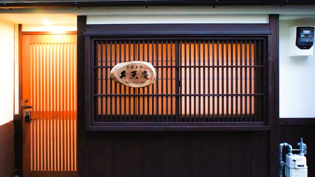 Um portão japonês tradicional com uma placa que diz 'Benten-an Inn'.