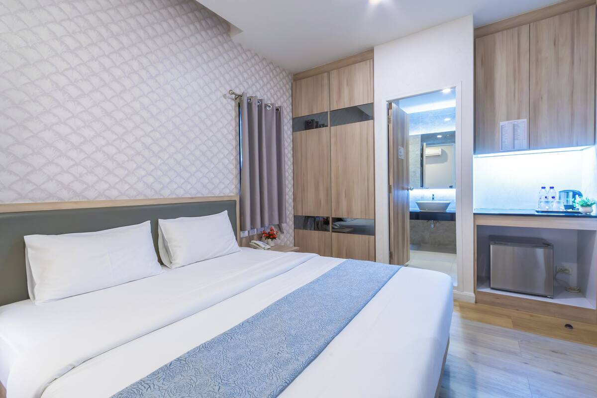 Une chambre d’hôtel moderne dotée d’un grand lit, d’un bureau intégré et d’une kitchenette.