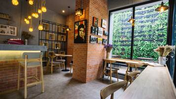 A cozy cafe with wooden furniture, a brick accent wall, and framed Beatles memorabilia.