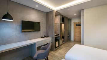 A modern hotel room with a desk, chair, and a bed.