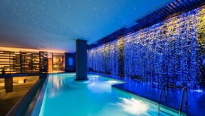 A modern indoor pool area with a starry ceiling and a wall covered in lights. - Nadee 10 Resort & Hotel (Khon Kaen)