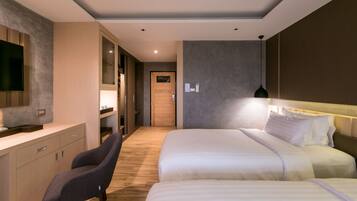 Une chambre d’hôtel moderne avec un grand lit, un bureau avec une chaise, une télévision et une porte en bois.