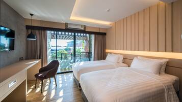 A modern hotel room with two beds, a desk, and a chair.