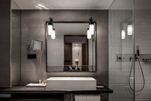 A modern bathroom with a large mirror, a white sink, and a handheld showerhead. - Chongqing David‘s Deer Boutique Hotel (Chongqing)
