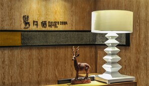 A wooden wall with a mounted deer sculpture and a lamp. - Chongqing David‘s Deer Boutique Hotel (Chongqing)