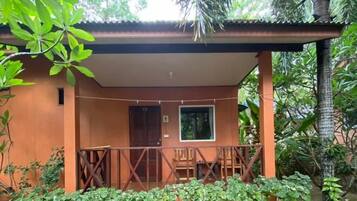 A single-story building with a covered porch, a door, and a window.