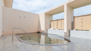 A swimming pool with a metal ladder, surrounded by tiled flooring and beige walls. - Lakeside Hot Spring Hotel Kunibiki (Izumo)