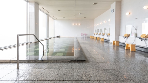 A spacious public restroom with a long corridor, multiple sinks, and benches. - Lakeside Hot Spring Hotel Kunibiki (Izumo)