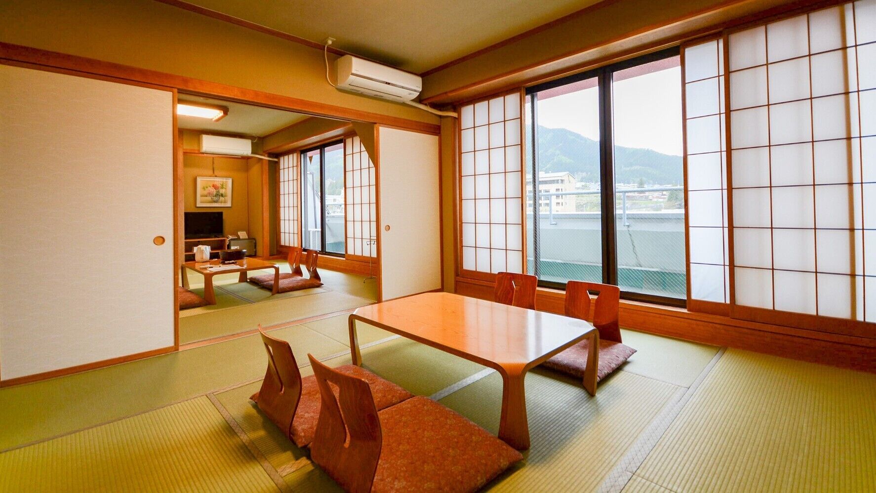 Une pièce de style japonais traditionnel, avec un sol recouvert de tatamis, une table basse et des portes coulissantes.