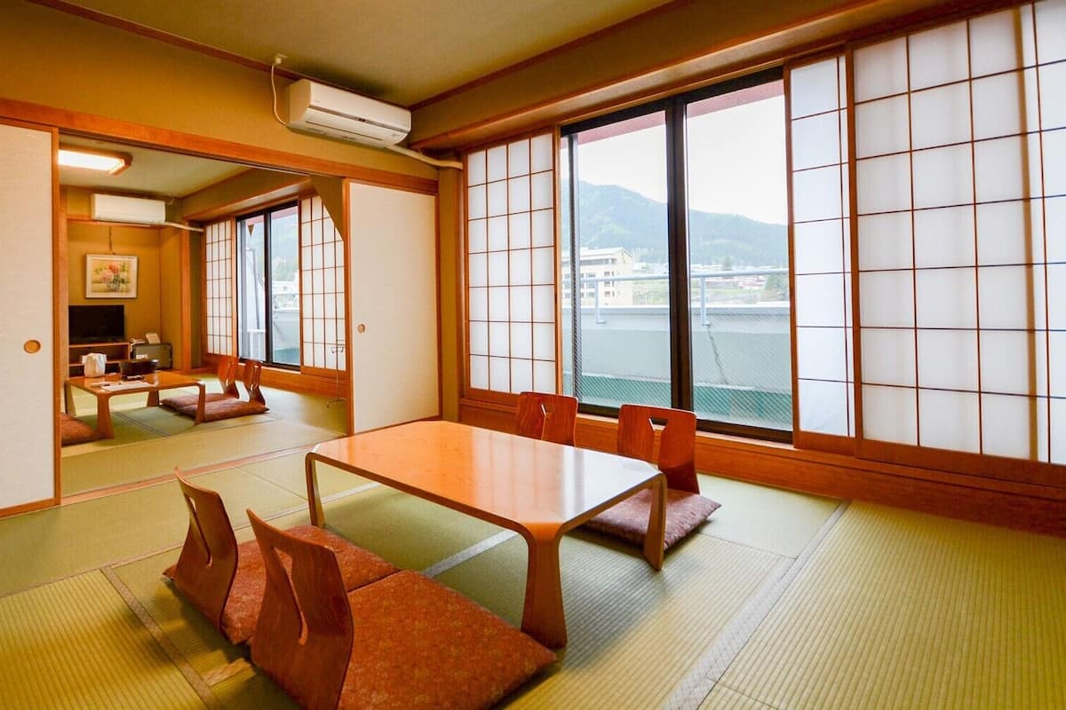 A traditional Japanese room with tatami flooring, a low table, and sliding doors.