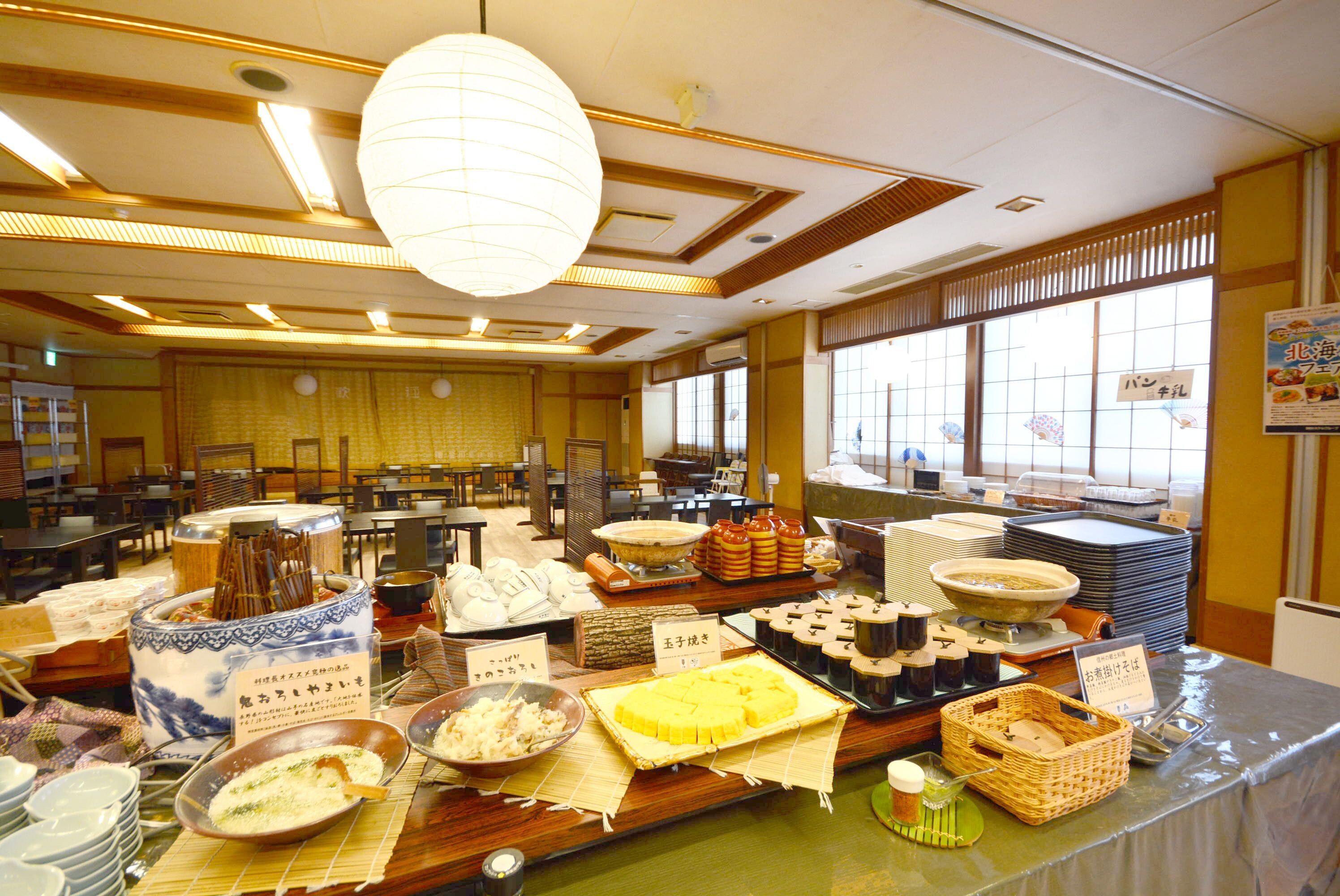 Uma área de buffet com diversos alimentos e pratos expostos em mesas.