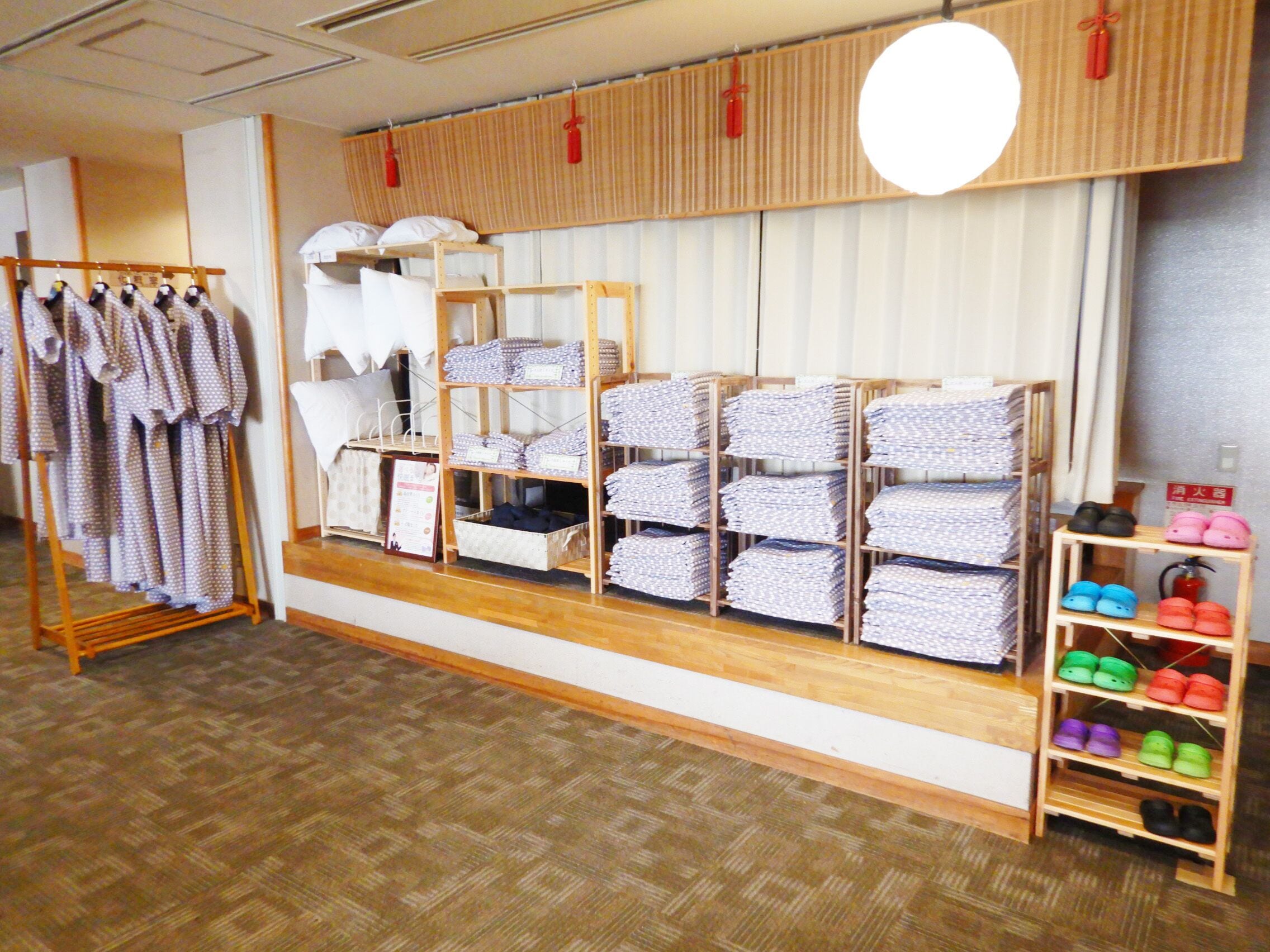 A store with shelves of folded clothes and a rack of hanging clothes.
