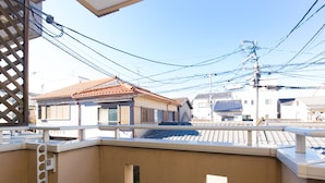 Un balcón con vistas a edificios tradicionales japoneses y un cielo despejado.