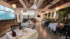 A restaurant with tables set for dining, a bar area, and a view of the outdoors. - Lavender Angkor Boutique (Siem Reap)