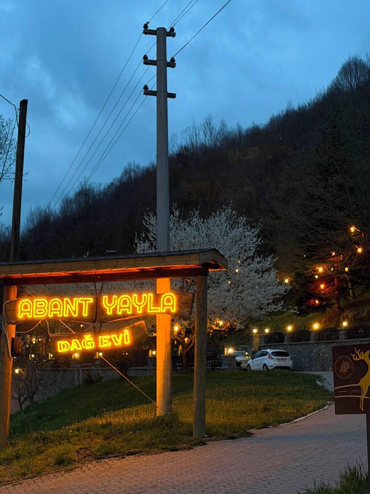 A wooden structure with a neon sign reading 'ABANT YAYLA' and 'DAĞ EVİ'.