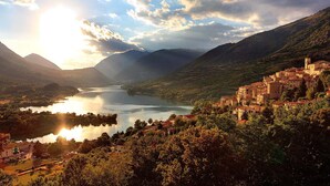 A mountainous landscape with a lake, a village with traditional architecture, and a clear sky. - Hotel Holidays (Barrea)