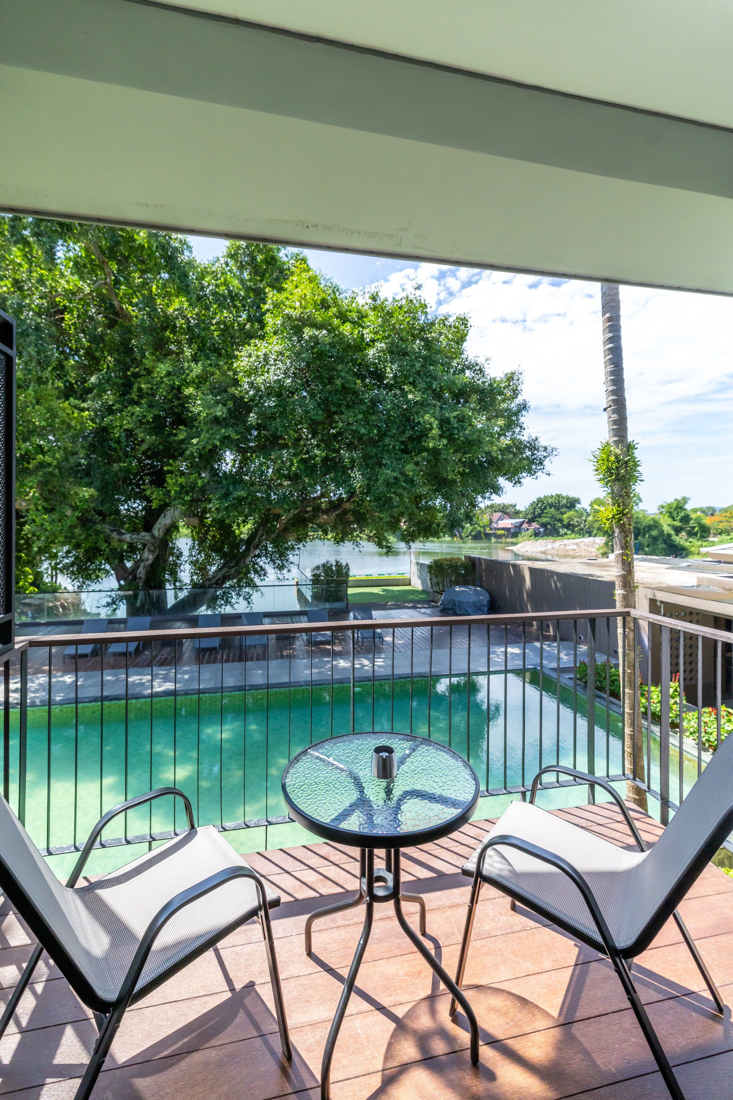 Ein Balkon mit Pool, zwei Stühlen und einem Tisch.