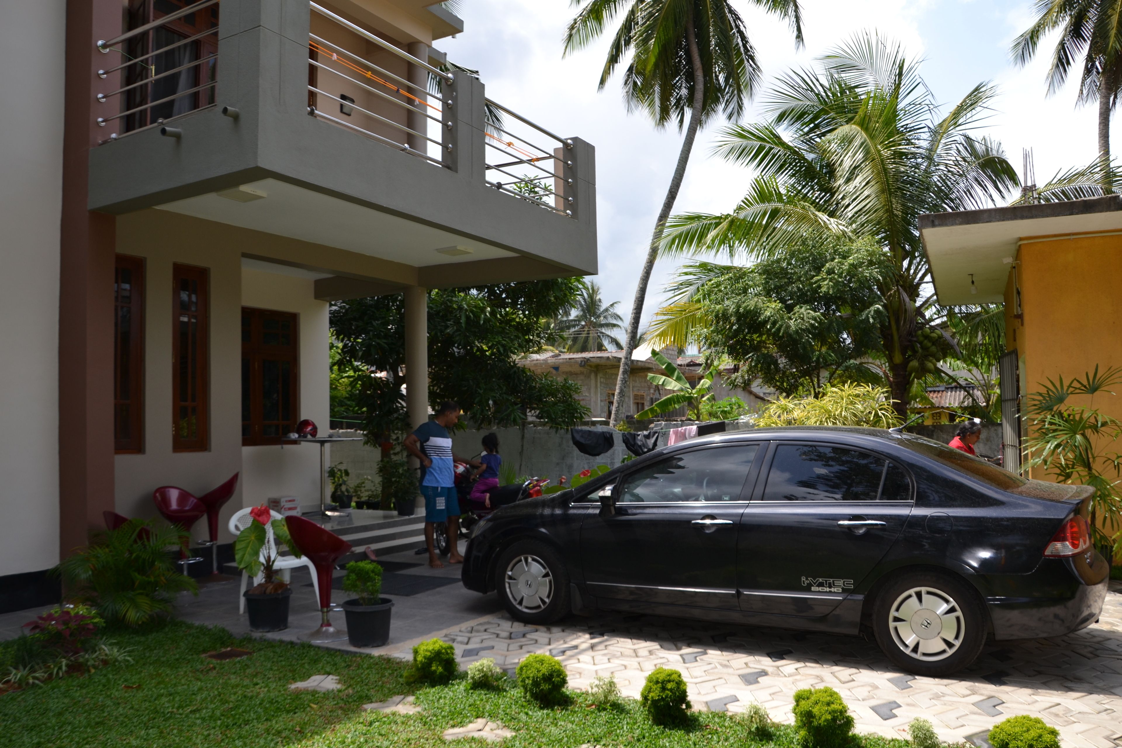 A modern two-story house with a car parked in the driveway.