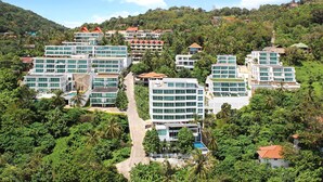 A resort with multiple buildings, lush greenery, and a clear sky. - Shanaya Residence Ocean View Kata (Karon)