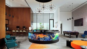A modern lobby with a central bar area, seating, and a pool table. - Aloft by Marriott Me’aisam, Dubai (Dubai)