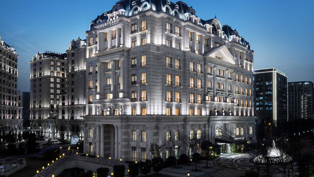 A large, historic building with a grand facade, multiple balconies, and a prominent entrance.