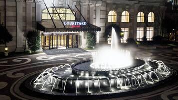 Ingresso di un hotel Courtyard Marriott con una fontana al centro.