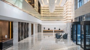 A spacious lobby with a reception desk, seating area, and modern architectural design.